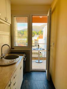 a kitchen with a sink and a view of a patio at Milion in Tivat