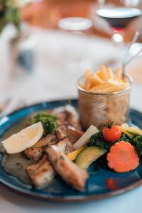 Relais Fleuri في Chermignon-dʼen Bas: طبق من الطعام مع اللحوم والخضروات على الطاولة