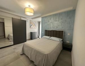 ein Schlafzimmer mit einem Bett und einer blauen Wand in der Unterkunft Fancy Modern APT Sliema - w/ 2BR in Sliema