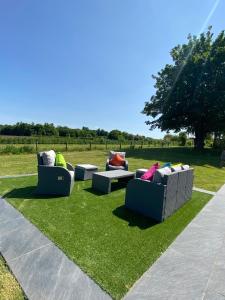 four couches sitting on the grass in a field at Stunning modern home set in beautiful grounds. in Bath