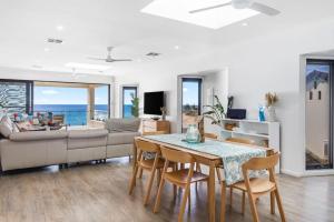 a living room with a table and chairs and a couch at Seascape Christies Ocean Views in Christies Beach
