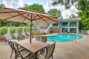 uma mesa com um guarda-sol ao lado de uma piscina em Spacious Rochester Home with Heated Pool and Hot Tub! em Rochester