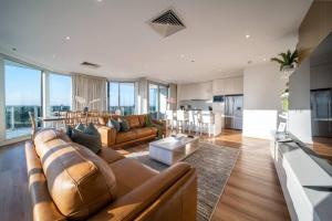 a large living room with a couch and a kitchen at The Views Penthouse Adelaide in Adelaide