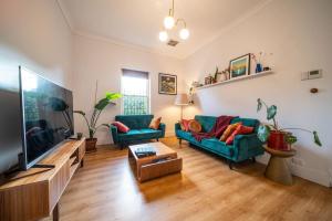 UnleyThat 70s Cottage Parkside Cottage Backyard WiFi的配有两张沙发和一台平板电视的客厅