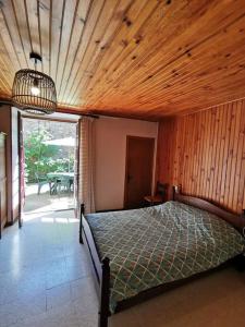 a bedroom with a bed and a wooden ceiling at Maison proche rivière - 6 à 8 personnes in Chambonas