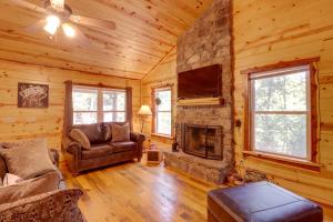 Cabaña de madera con sala de estar con chimenea de piedra. en Romantic Mountain View Cabin Rental Near Downtown!, en Mountain View