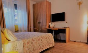 a bedroom with a bed and a desk with a television at L'angolo di Luna in Gorizia