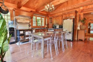 a large kitchen with a table and chairs at Chalet Le Crépuscule SPA, BILLARD, FOYER, SENTIERS PRIVES in Chertsey