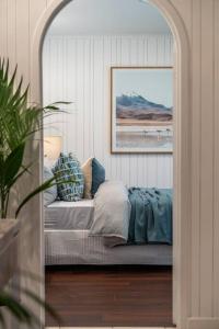 a room with a bed with a painting on the wall at La Brisa Waterfront Family Home Beach WiFi in Grange