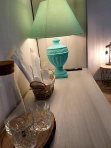 une table avec une lampe verte et des verres dessus dans l'établissement L'angolo di Luna, à Gorizia