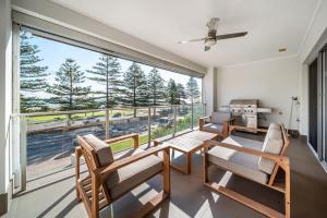 Zimmer mit einem Balkon mit Tisch und Stühlen in der Unterkunft Beach Haven at Semaphore in Port Adelaide