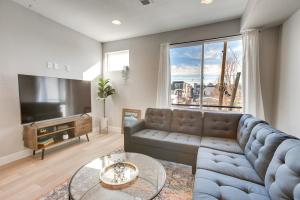 uma sala de estar com um sofá e uma grande janela em Modern Townhome with Rooftop Hot Tub and Mtn View em Denver