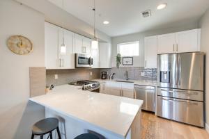uma cozinha com armários brancos e electrodomésticos de aço inoxidável em Modern Townhome with Rooftop Hot Tub and Mtn View em Denver