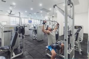 a man in a gym performing a barbell workout at 37th Floor - SkyView Oasis - C in Skopje