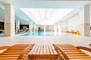 a swimming pool with benches in a building at 37th Floor - SkyView Oasis - C in Skopje