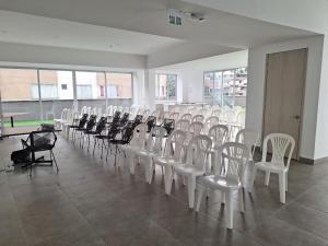 una habitación con filas de sillas y mesas y andermott en Confortable apartamento, en Manizales