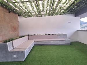 Zimmer mit einer Bank und grünem Gras in der Unterkunft Confortable apartamento in Manizales