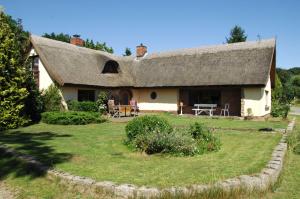 een huis met een rieten dak en een tuin bij Reeddachhaus mit Seeblick - Ruhe - traumhafter Lage am Selliner See in Ostseebad Sellin