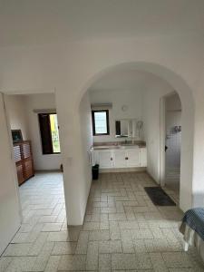 a large white room with a kitchen and a hallway at Cómodo Depa en Club Santiago in Manzanillo