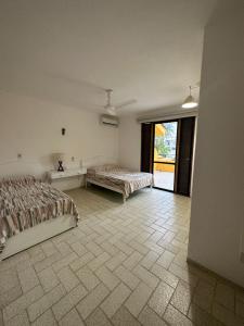 1 Schlafzimmer mit 2 Betten und einem großen Fenster in der Unterkunft Cómodo Depa en Club Santiago in Manzanillo