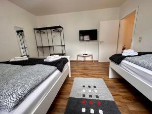a room with two beds and a television in it at Kartels First Appart in Kierspe