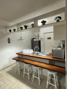 a kitchen with a counter with a sink and stools at Cómodo Depa en Club Santiago in Manzanillo