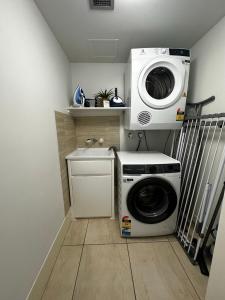 a washing machine and a washer in a laundry room at Beach Front Ocean View 3 Bedroom Apartment in Maroochydore in Maroochydore