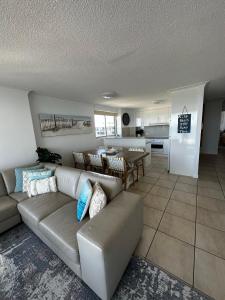 a living room with a couch and a kitchen at Beach Front Ocean View 3 Bedroom Apartment in Maroochydore in Maroochydore