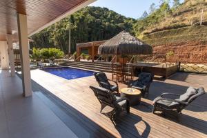 an outdoor deck with chairs and a swimming pool at Sítio Cinco Folhas, recanto com vista pra montanha in Marechal Floriano