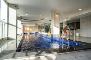 a lobby with a swimming pool in a building at Illuminate North Terrace - Executive CBD in Adelaide