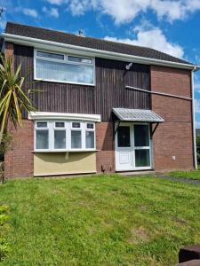 a red brick house with a white door at 5 bedroom house - Cheshire Oaks in Ellesmere Port