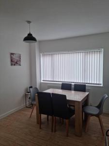 uma sala de jantar com mesa e cadeiras em 5 bedroom house - Cheshire Oaks em Ellesmere Port