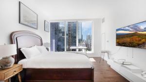 Dormitorio blanco con cama y ventana grande en Lux 2 Bedroom 1 Bath Suite in Hudson Yards en Nueva York