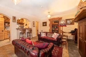 ein Wohnzimmer mit einem Ledersofa und einer Bar in der Unterkunft Burrow at Botanic in Adelaide + 11 Fotos