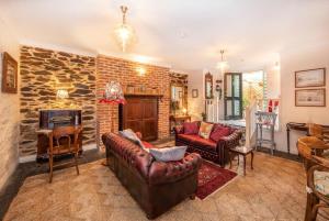 ein Wohnzimmer mit Ledermöbeln und einer Steinmauer in der Unterkunft Burrow at Botanic in Adelaide