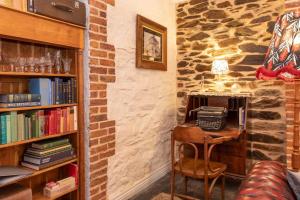 ein Raum mit einer Steinwand mit einem Schreibtisch mit einem Telefon in der Unterkunft Burrow at Botanic in Adelaide