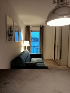 a living room with a couch and a large window at Menton - SABLETTES BEACH VIEW in Menton