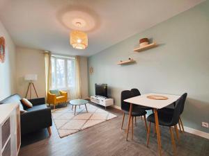 un soggiorno con divano, tavolo e sedie di Joli T2 Le Moderne a Riom