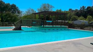 a swimming pool with a gazebo next to it at Mobilhome Labenne Océan in Labenne