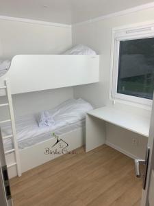 niewielka sypialnia z łóżkiem piętrowym i biurkiem w obiekcie Bungalow Camping Jacuzzi & Sauna w Solinie