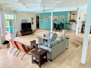 sala de estar con sofá, sillas y TV en Hidden Valley Villa en Teagues Bay