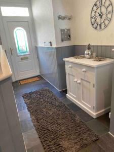 a bathroom with a counter and a door and a rug at 5 min walk to Beaches & Pembrokeshire Coast Path in Pembrokeshire