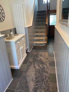 a hallway with a staircase and a rug on the floor at 5 min walk to Beaches & Pembrokeshire Coast Path in Pembrokeshire