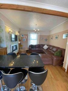 a living room with a couch and a table and chairs at 5 min walk to Beaches & Pembrokeshire Coast Path in Pembrokeshire