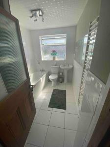 a bathroom with a toilet and a sink and a window at 5 min walk to Beaches & Pembrokeshire Coast Path in Pembrokeshire