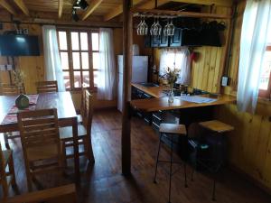 een keuken en eetkamer met een tafel en stoelen bij Cabañas en los reartes in Los Reartes