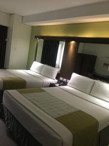 a hotel room with two beds with white pillows at Homie Sweetie in Morong