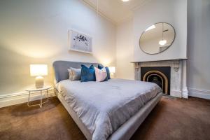 a bedroom with a bed with a fireplace and a mirror at Irmas Place on Halifax in Adelaide