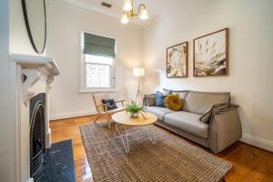 a living room with a couch and a table at Irmas Place on Halifax in Adelaide