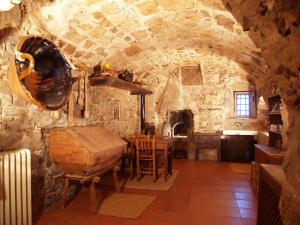 eine Küche mit einem Tisch und einer Steinmauer in der Unterkunft Mas El Soler de Terrades - Turisme Rural in Moià